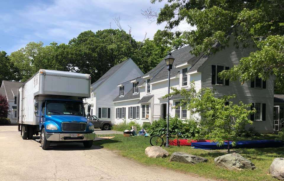 Moving truck parked outside of a white house in Sutton, Massachusetts.
