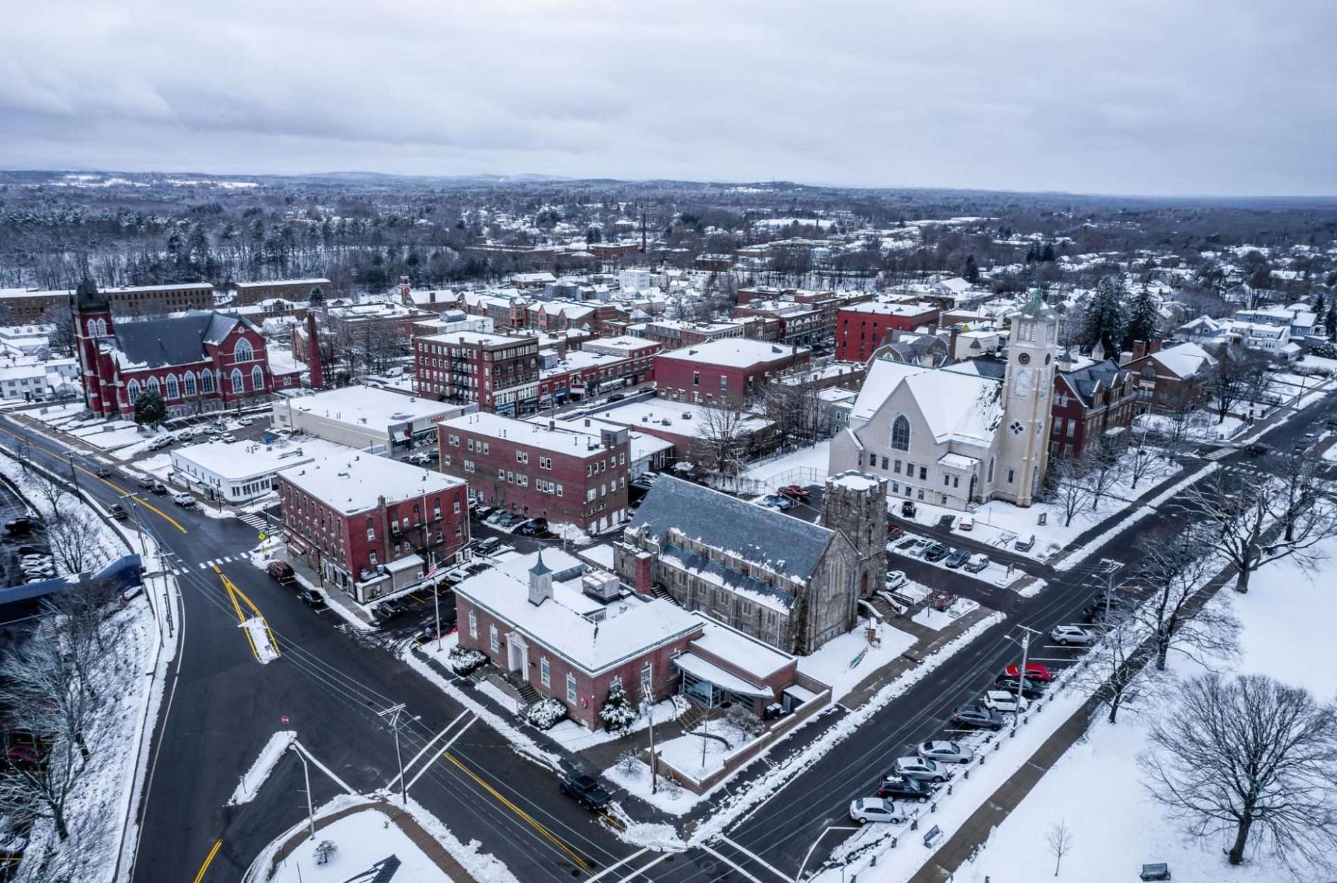 Aerial shot of Clinton MA in the winter, with buildings covered in snow
