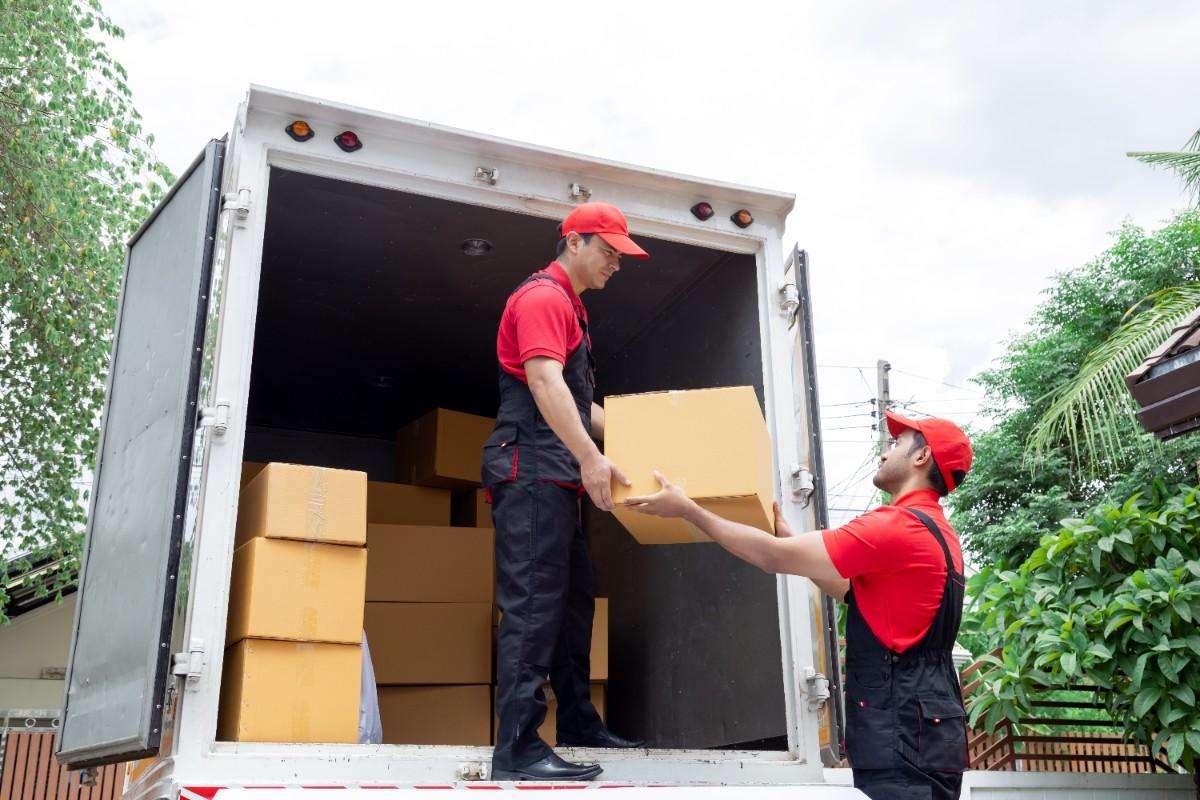 Two Fitchburg movers loading boxes into the back of the truck