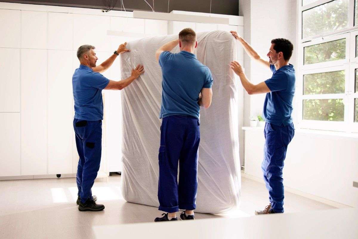 Fitchburg movers in blue polo shirts handling a mattress