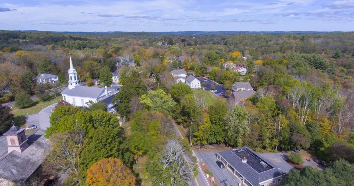An aerial view of a church, homes, and public spaces in Sherborn