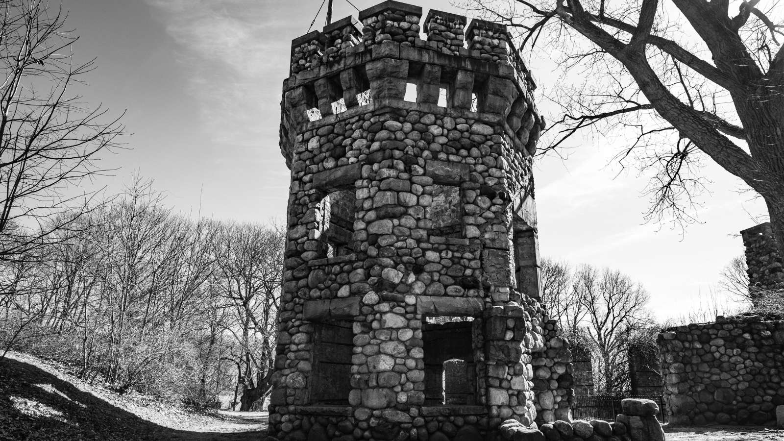 Bancroft's Castle in Groton MA. A black and white picture of an old castle set against bare trees.